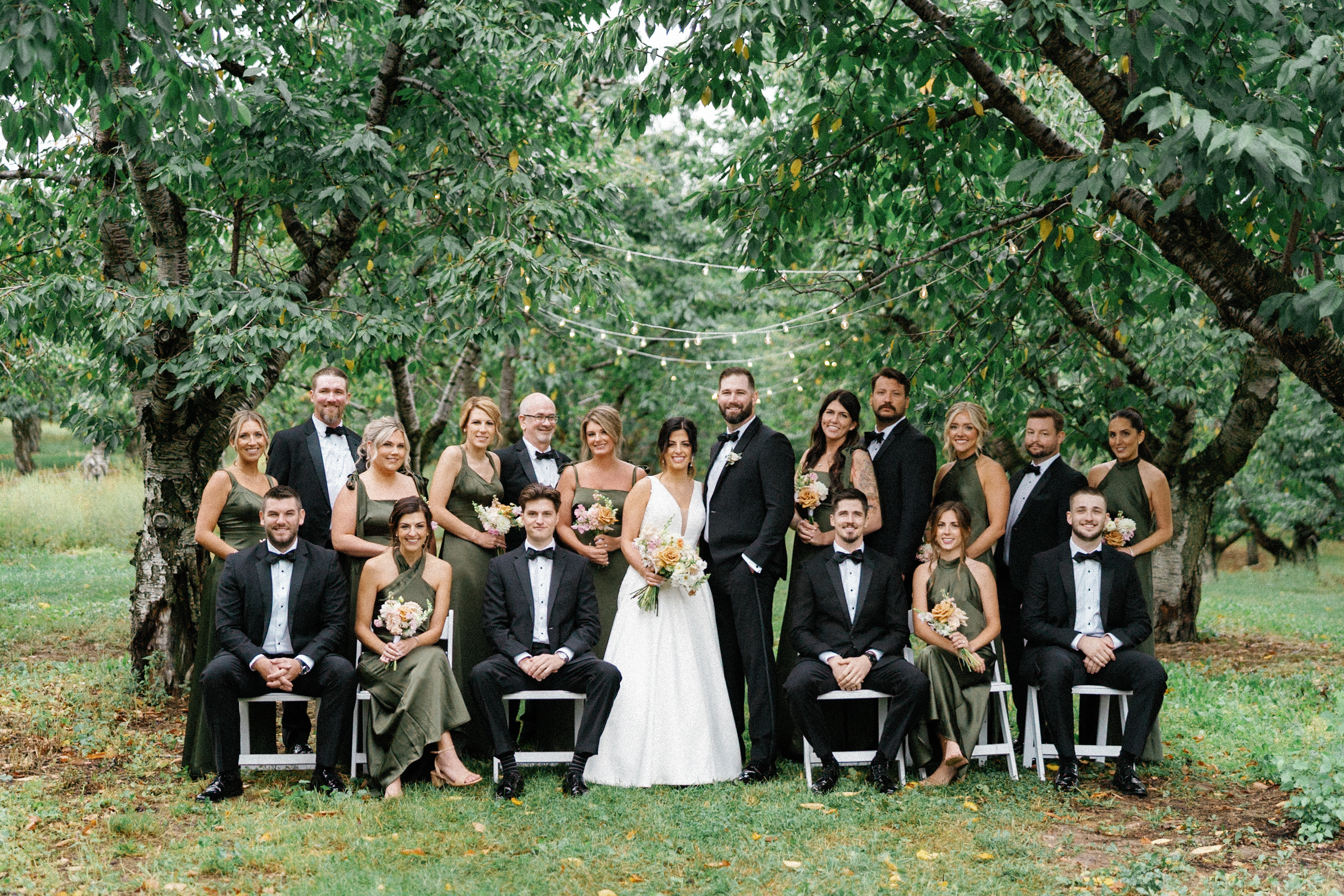 Wedding party with the bride and groom beneath garden trees