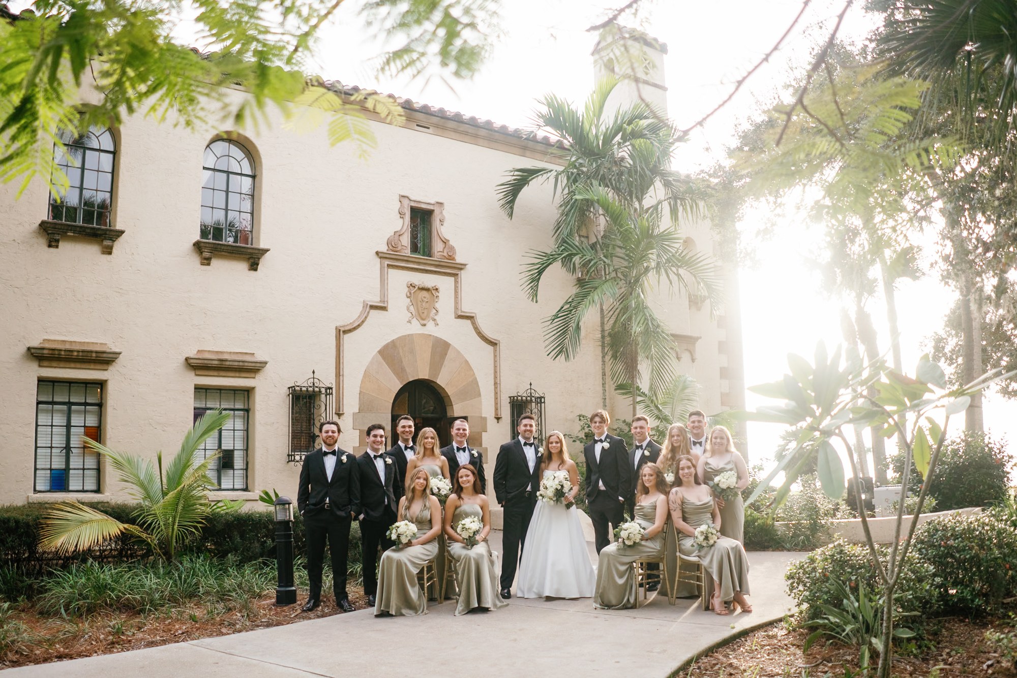 Wedding party outside a sunlit Mediterranean-style villa