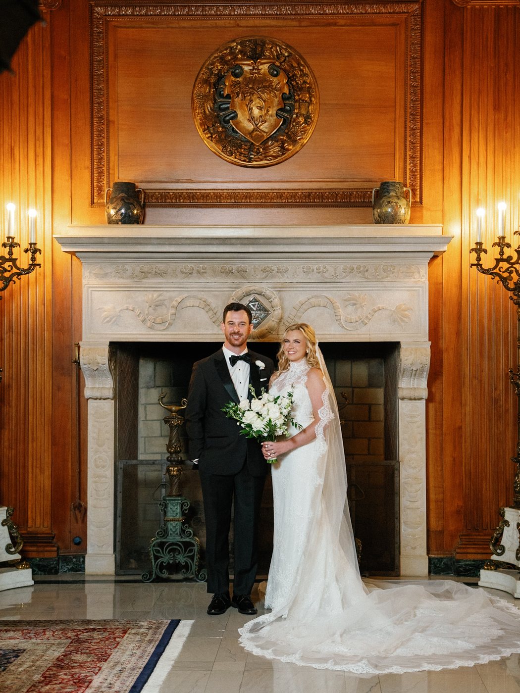 Couple beside a fireplace in a warmly lit room, after editing; photograph by Michele Maloney