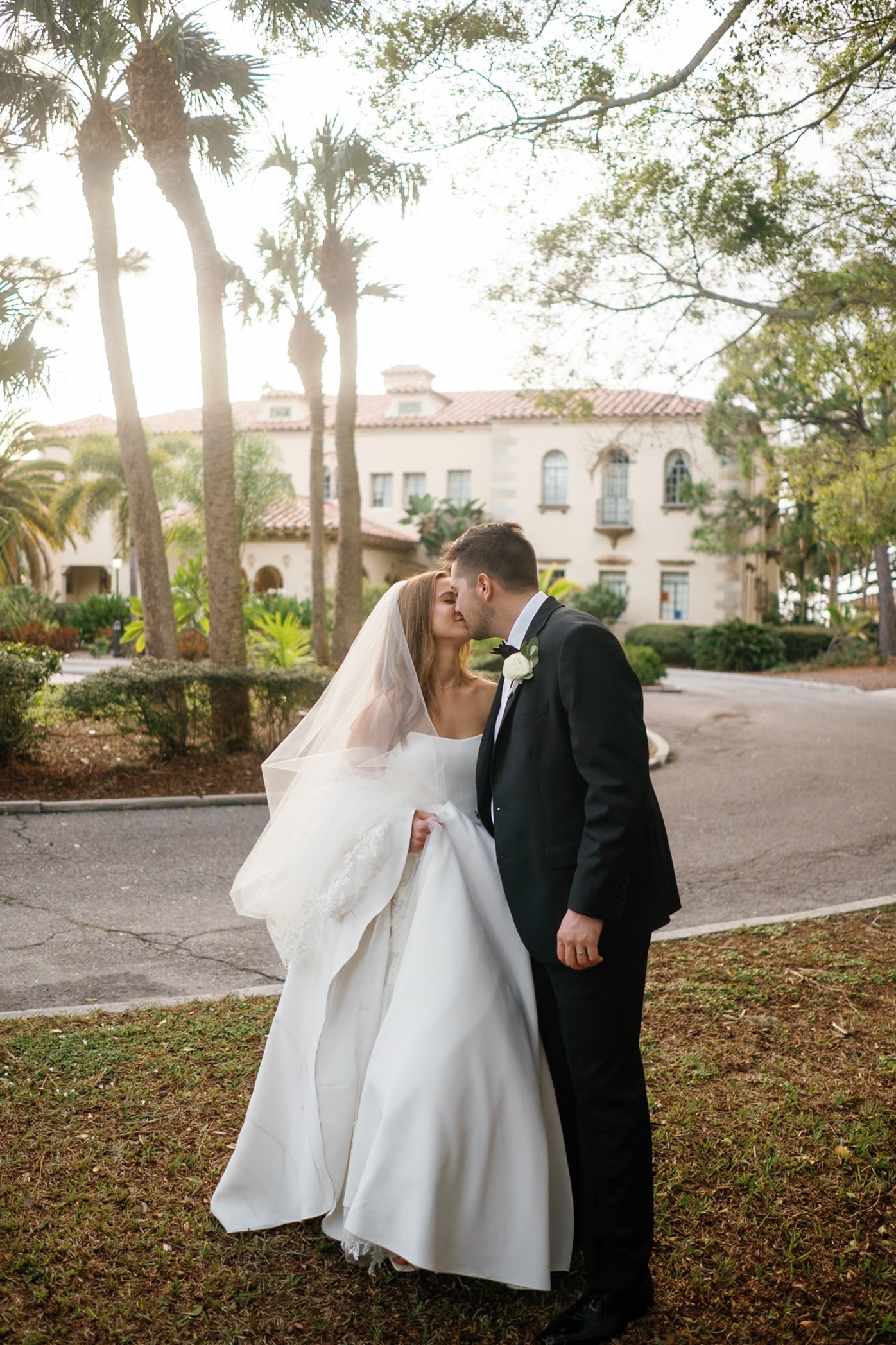 Newlyweds beneath palms in backlight, after editing