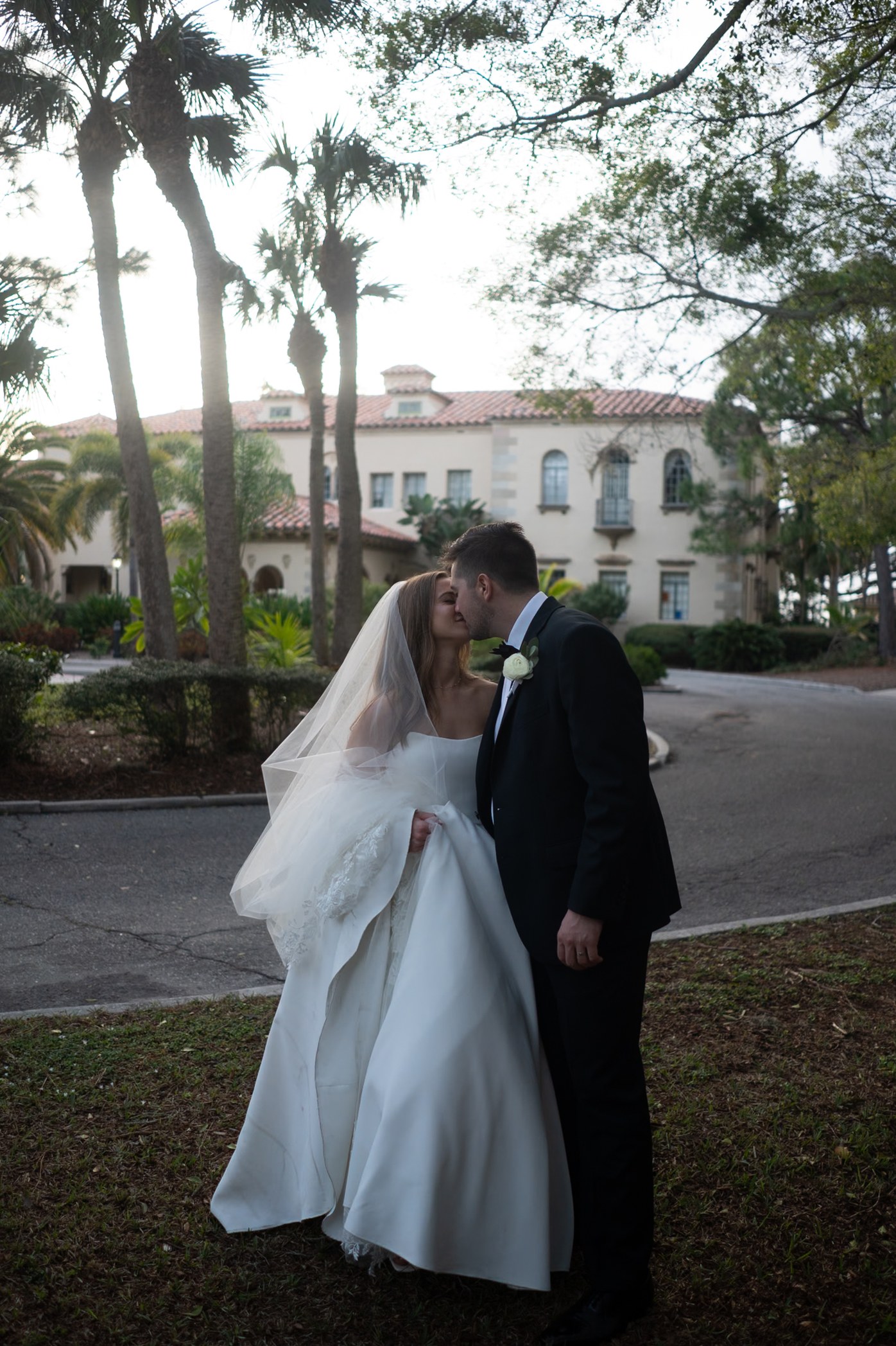 Newlyweds beneath palms in backlight, before editing