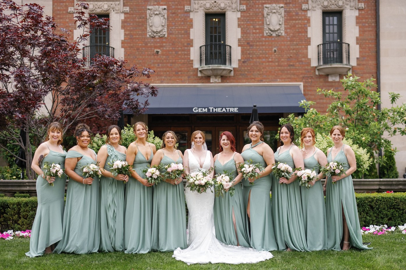 Wedding party in pale green dresses outside a theatre, before editing
