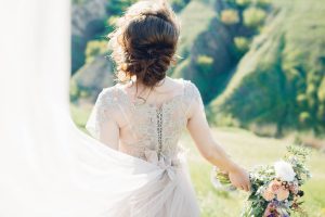 fine art wedding photography. beautiful bride with bouquet and dress with train in nature