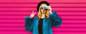 portrait of stylish blonde young woman photographer with film ca