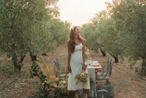 delighted bride standing near banquet table in summer garden