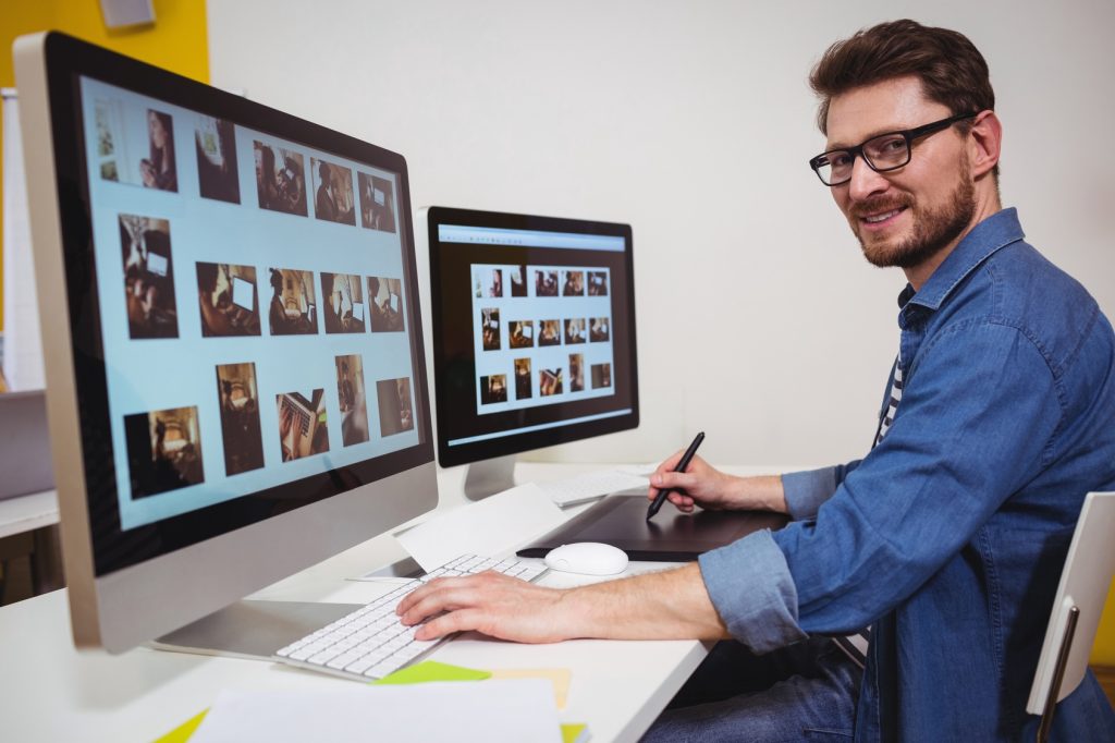 portrait of male photo editor working on computer