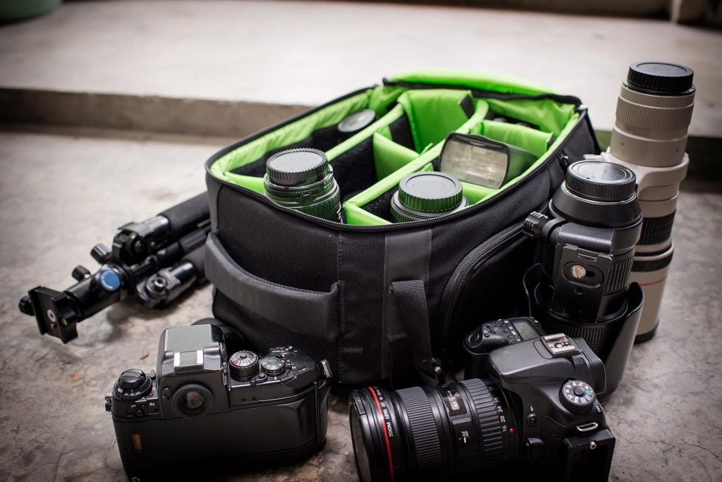 photographer pack his camera and lenses to bagpack.